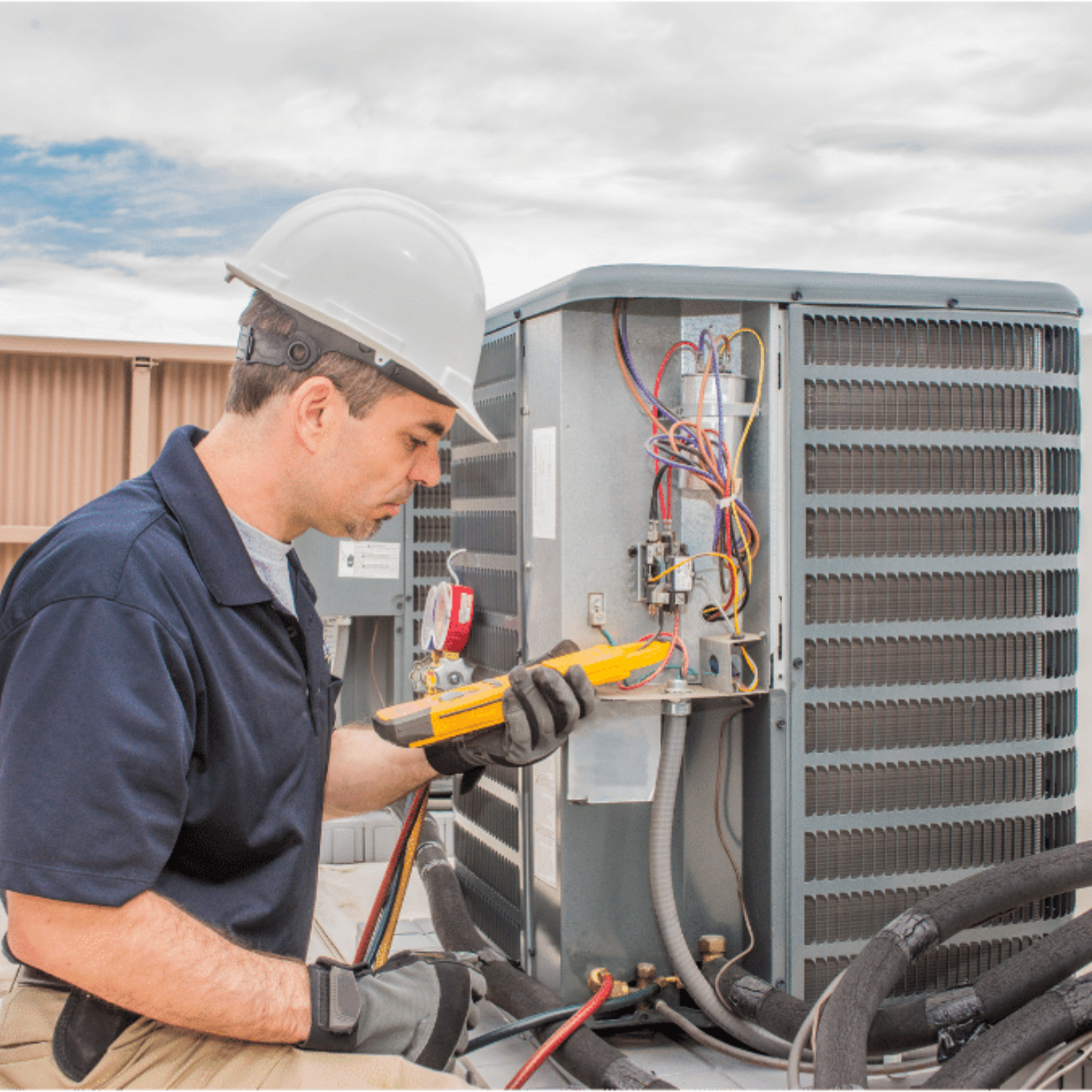 Ingersoll Heating & Cooling HVAC technician servicing a system