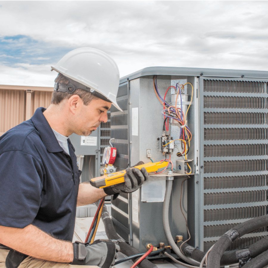 Ingersoll Heating & Cooling HVAC technician servicing a system
